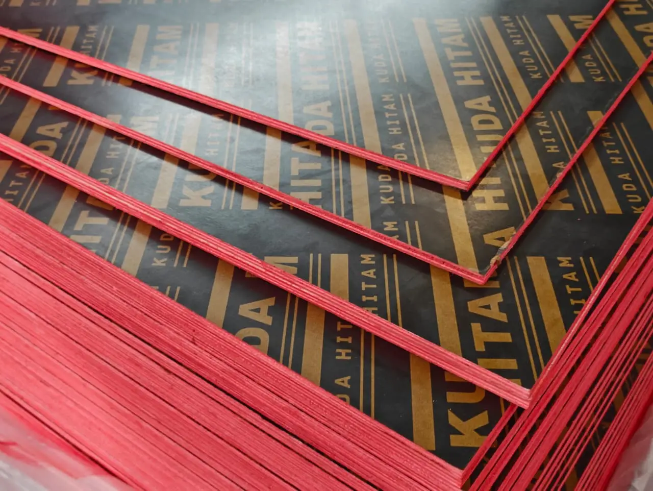 title Distributor Triplek & Plywood Phenolic di Semarang Tumpukan plywood phenolic film face Kuda Hitam dengan lapisan film hitam bertuliskan KUDA HITAM dan pinggiran panel berwarna merah